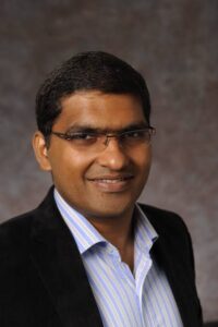 Man with glasses and black suit