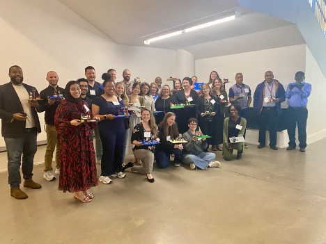 Participants of the May 2025 Course Design Institute gather for a group photo while holding their completed LEGO activity projects.