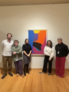 Professors stand in-line next to art peice pictured at Zimmerli Art Museum. 