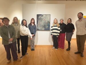 Students and professors standing in line with picture frame at Zimmereli Art Museum.