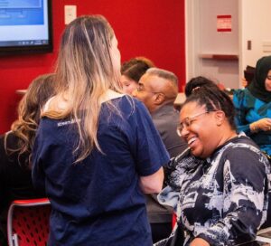 This photo shows two participants in conversation. One participant is laughing.