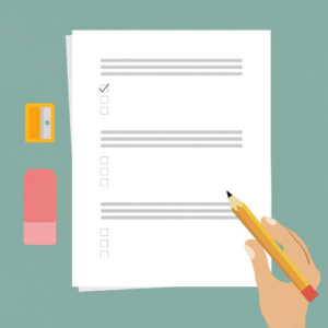 Graphically illustrated image of papers on a desk containing a multiple choice assessment. A person's hand is holding a pencil over the test. An eraser and a pencil sharpener are next to the test.