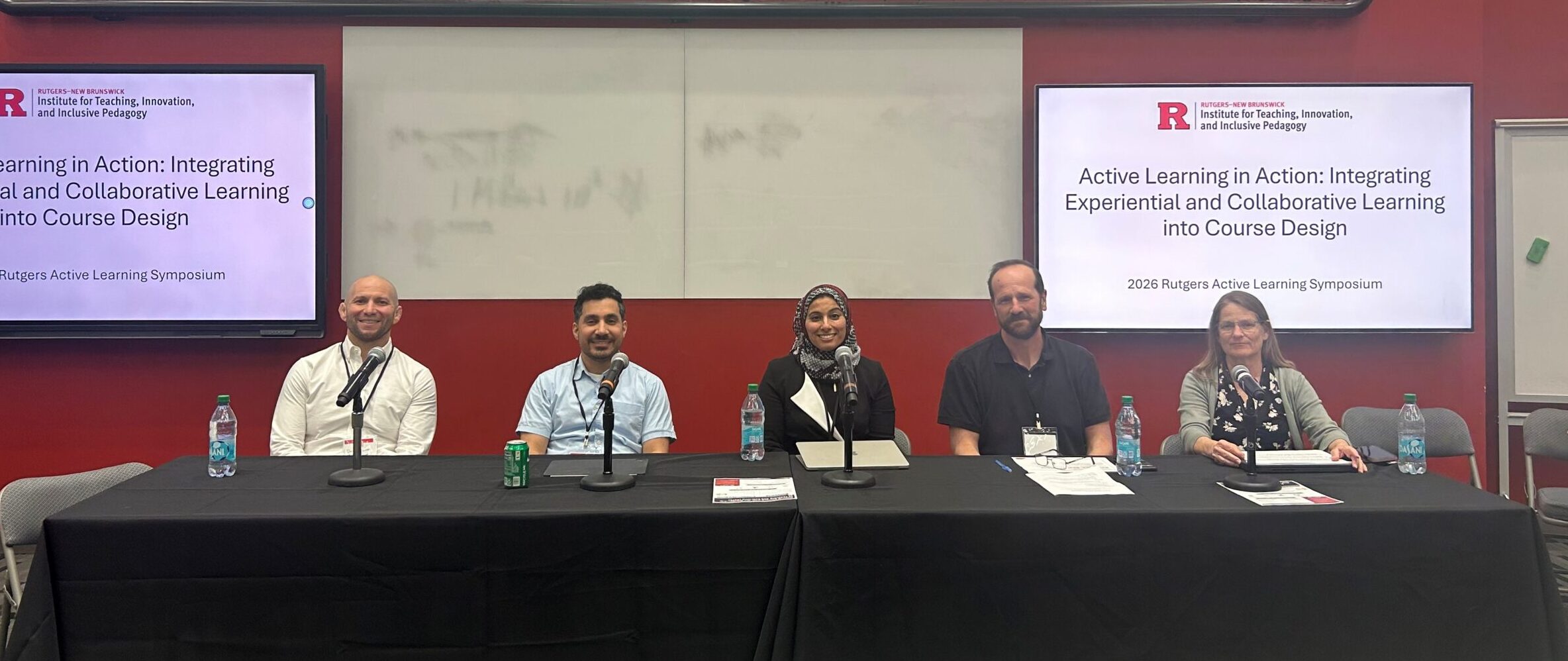 Five panelists participate in a discussion at the 2026 Rutgers Active Learning Symposium beneath presentation screens displaying “Active Learning in Action: Integrating Experiential and Collaborative Learning into Course Design.”