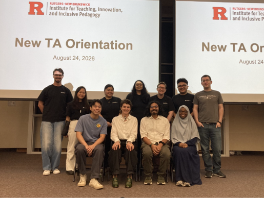 A group of people posing together in front of a large projector screen that reads "New TA Orientation, August 24, 2026".